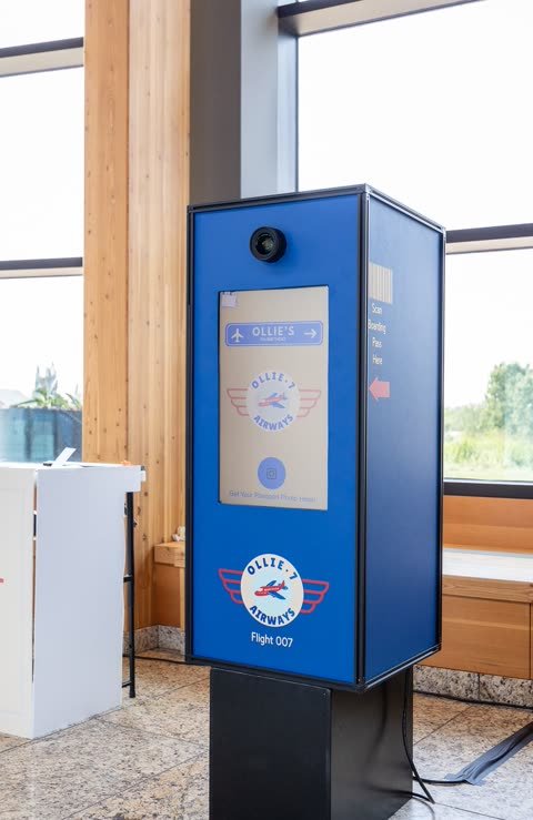 Custom aviation-themed Pick-A-Booth kiosk with boarding-pass wrap at a Calgary event.
